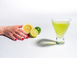 Cocktail glass with lemon juice and sliced citrus