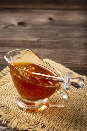 Honey in glass bowl on the table.
