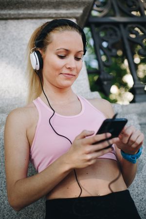 Woman with sportswear listening to music with headphones