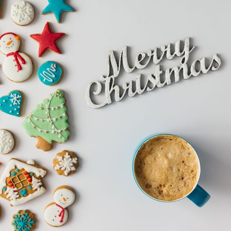 Pattern of Christmas cookies and red berries with coffee cup and “Merry Christmas” text