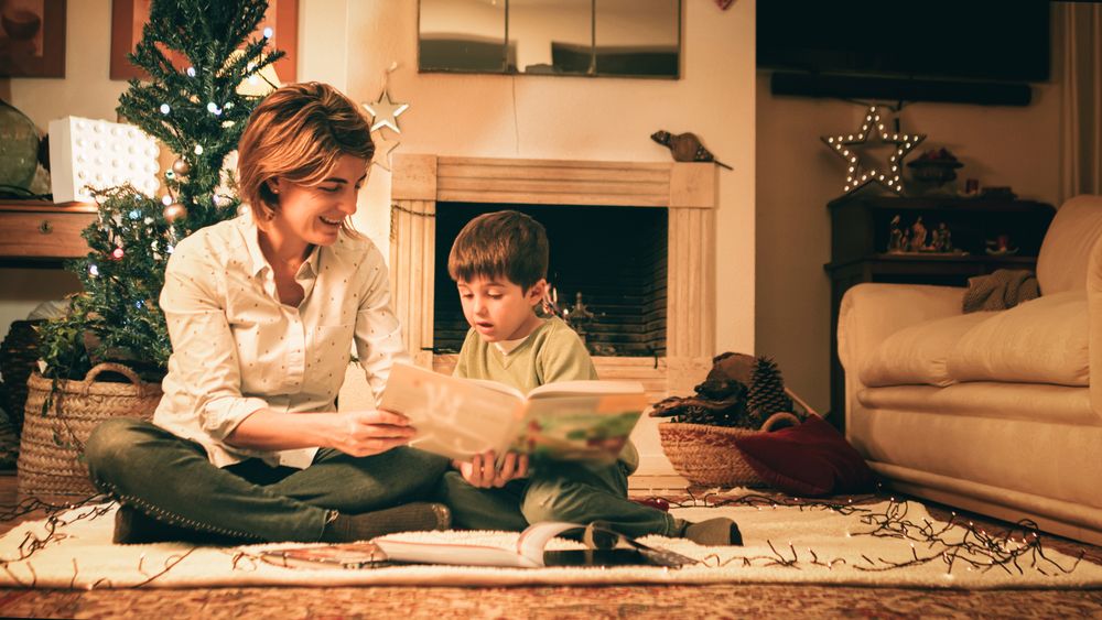 Mother reading book with son on Christmas eve