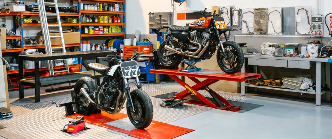 Banner of empty motorcycle workshop with custom motorbikes over platforms ready to repair