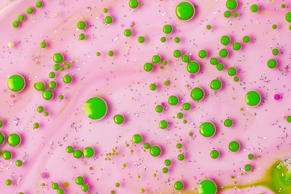 Green droplets on sparkly pink background