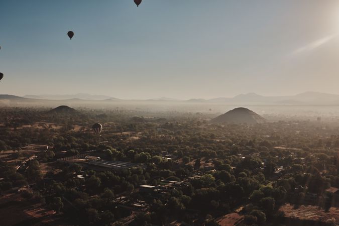 Hot air balloons flying above foggy morning in Teotihuacan Valley