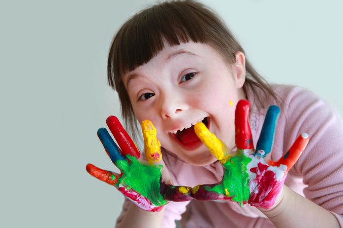 Adorable child using paints on her hands