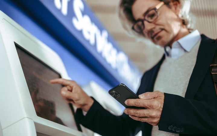 Business traveler making self check in at airport