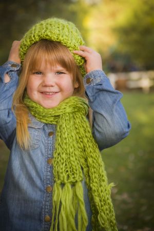 Portrait of Cute Young Girl Wearing Green Scarf and Hat
