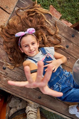 Delighted girl reaching hand to camera