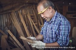Mature carpenter wearing eye protecting in woodshed 5pxqy5