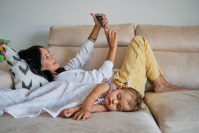 Woman and daughter relaxing on sofa at home