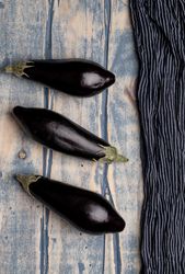Ripe eggplants on shabby tabletop