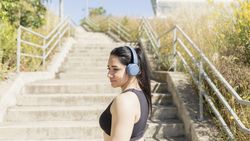 A woman listens to music, while mentalizing before starting a race by climbing stairs, Zaragoza, Spain