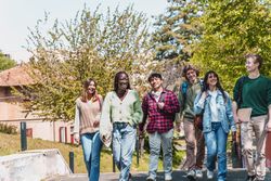 Multi-ethnic group of students walking through campus