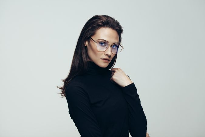 Portrait of confident woman in dark dress wearing glasses