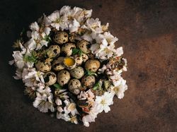 Quail eggs in flowers on table