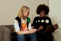 Two women working together on laptop in office