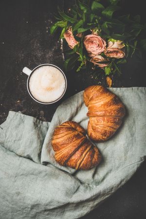 Coffee with croissants and pink roses