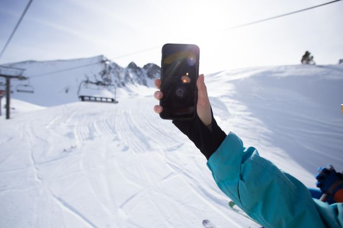 Arm taking a selfie on a ski lift