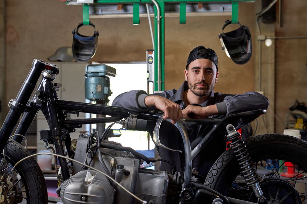 Serious mechanic repairing motorbike in garage