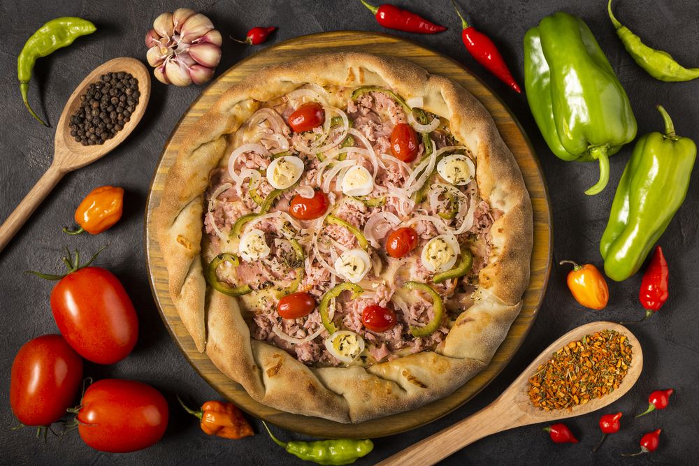 Empty pizza  board on the table with Ingredients for cooking