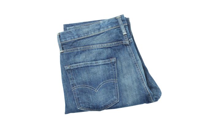 Close-up of folded jeans, isolated on light background