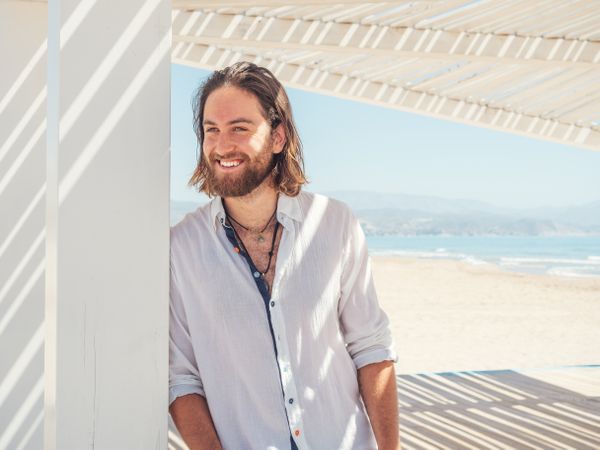 Relaxed man standing in gazebo on beach