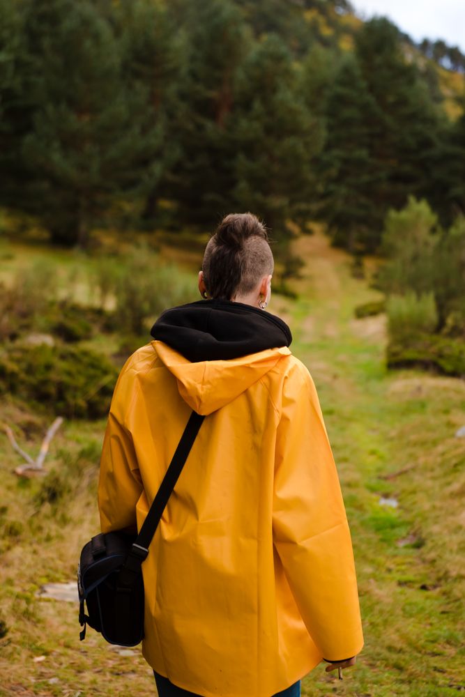 Person in yellow raincoat walking in forest