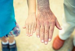 Child and older man comparing his hands size