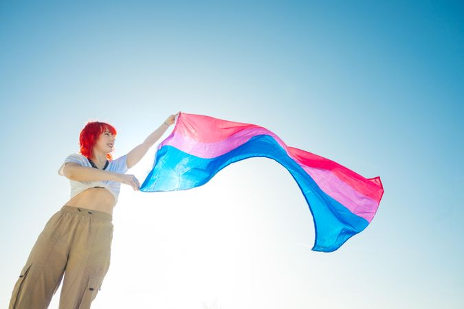 Woman with red hair waving a colorful flag