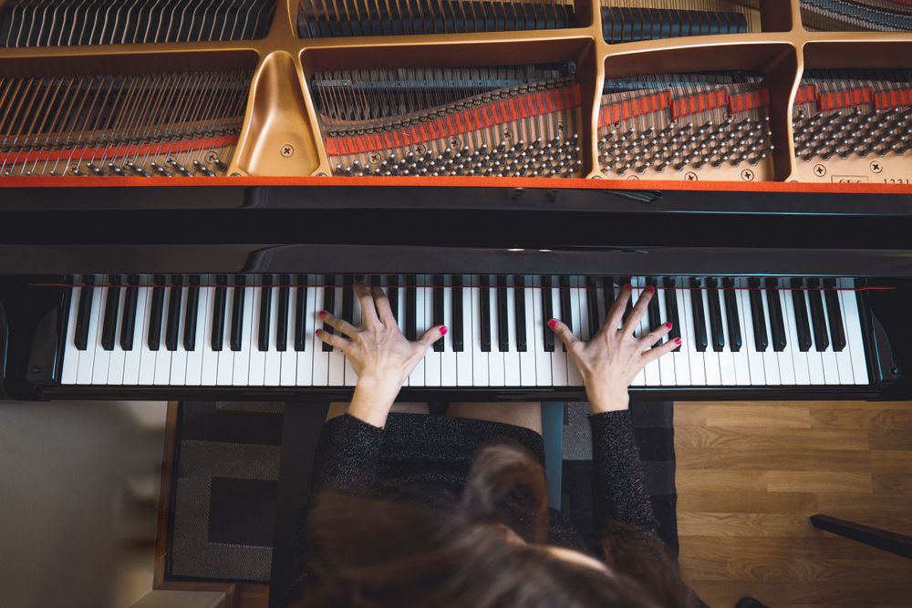 Top view of cropped hands playing the piano