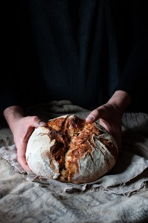 Crop person putting payes bread ob fabric