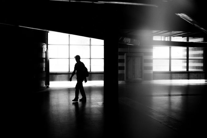 Man in cap walking through empty building