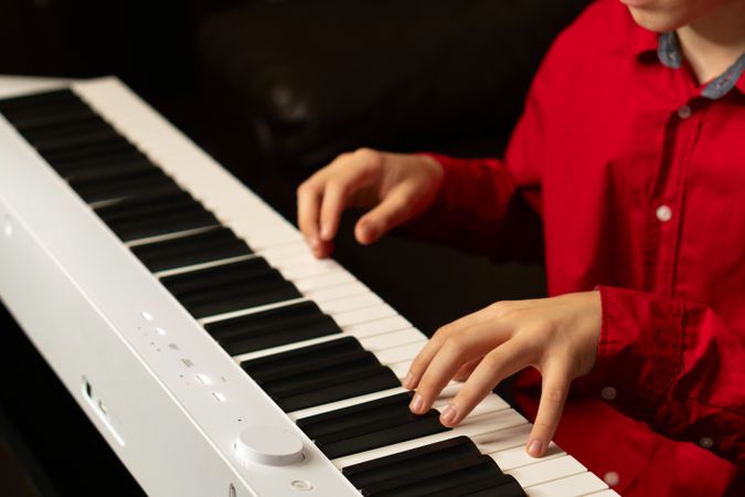 Young pianist's hands playing digital keyboard.