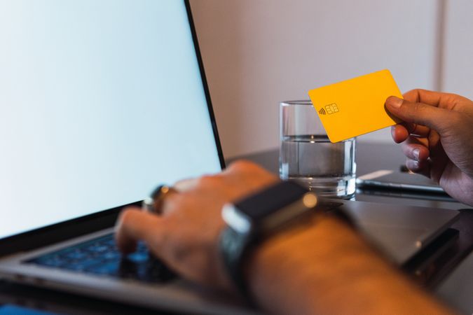 Anonymous man with credit card shopping online