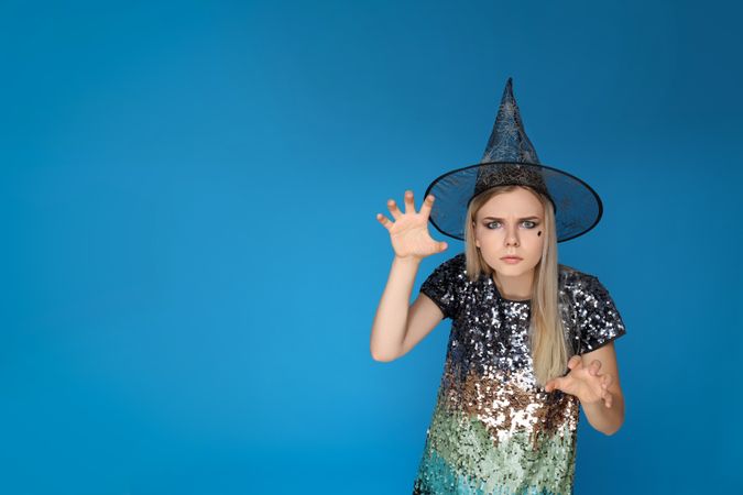 Concept of Halloween, young woman on blue background