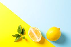 Flat lay composition with lemons on two tone background, space for text