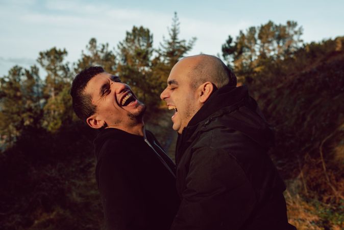 laughing men hugging in countryside road