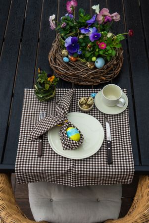 Easter table setting with checkered brown napkin and colorful decorative eggs