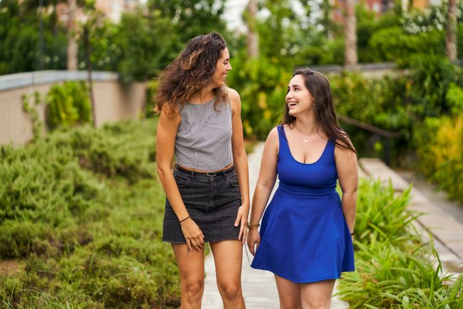 two friends talking while walking in the park