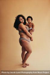 Happy woman celebrating her mom body with her baby bDN6k5