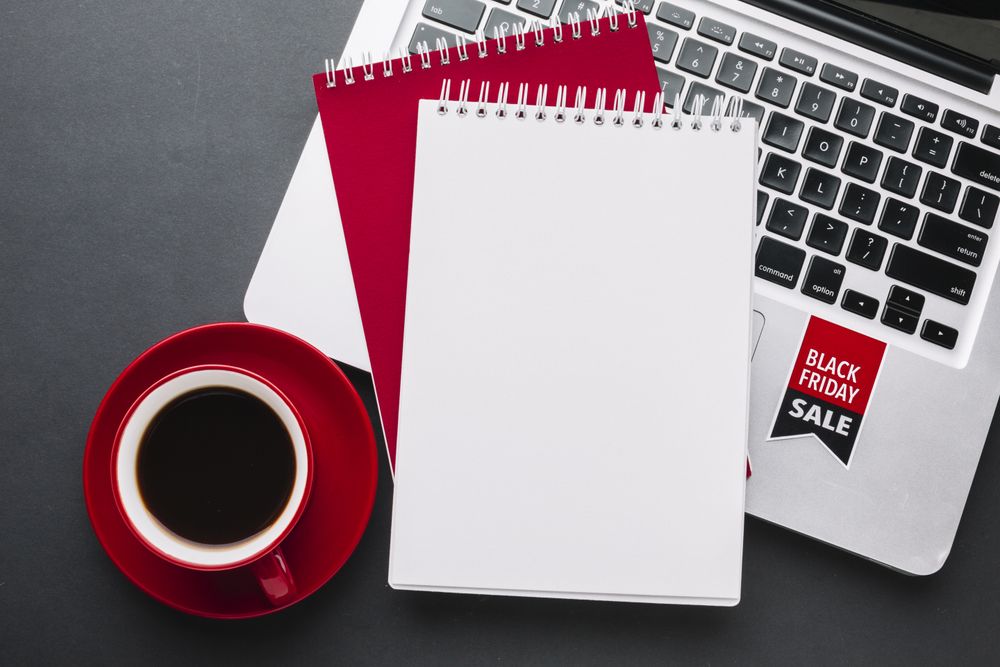 Top view of laptop on sale with notebook