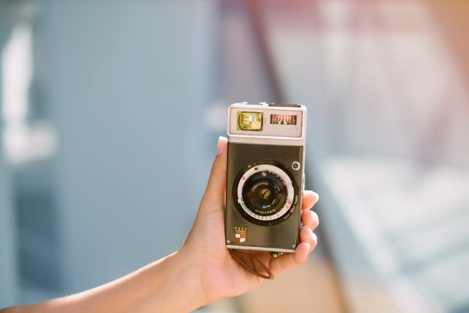 Creative woman taking photo on camera in sunny day