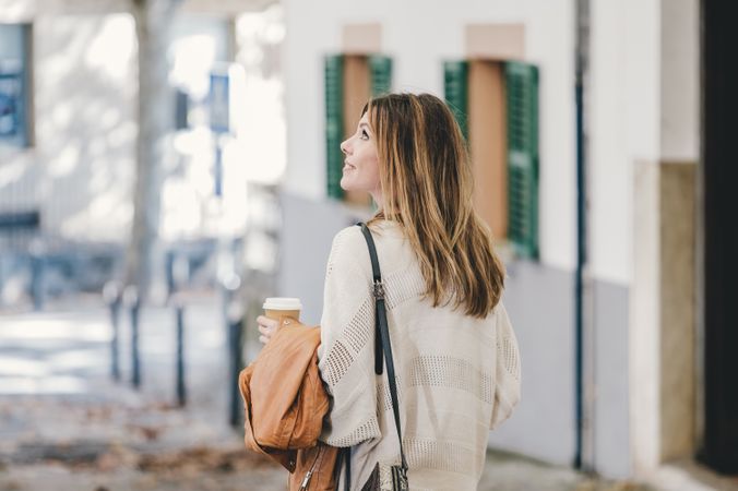Woman walking with cup of coffee