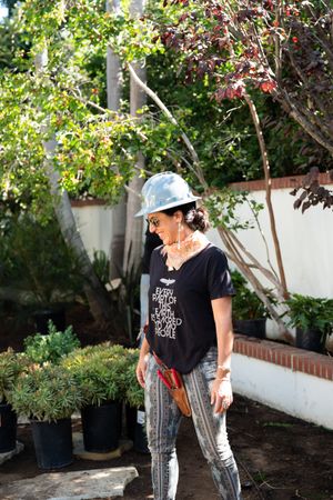 Smiling woman working in garden wearing hard hat