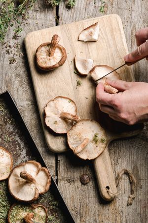 Person preparing fresh brown mushrooms for cooking