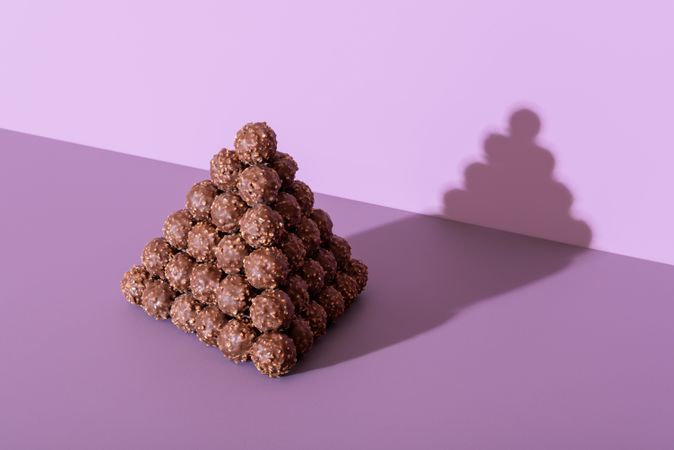 Chocolate truffles pyramid on a purple background