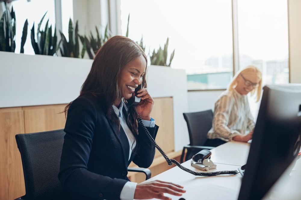 Woman smiling on the phone at the front desk