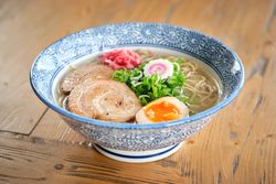 Delicious ramen soup with soft egg and pork meat in bowl