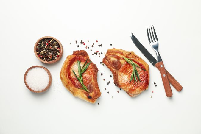 Fried steaks with spices on blank background, top view