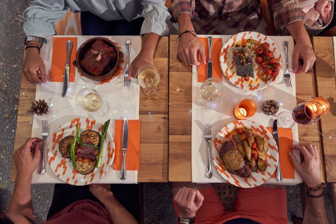Unrecognizable friends having dinner in restaurant